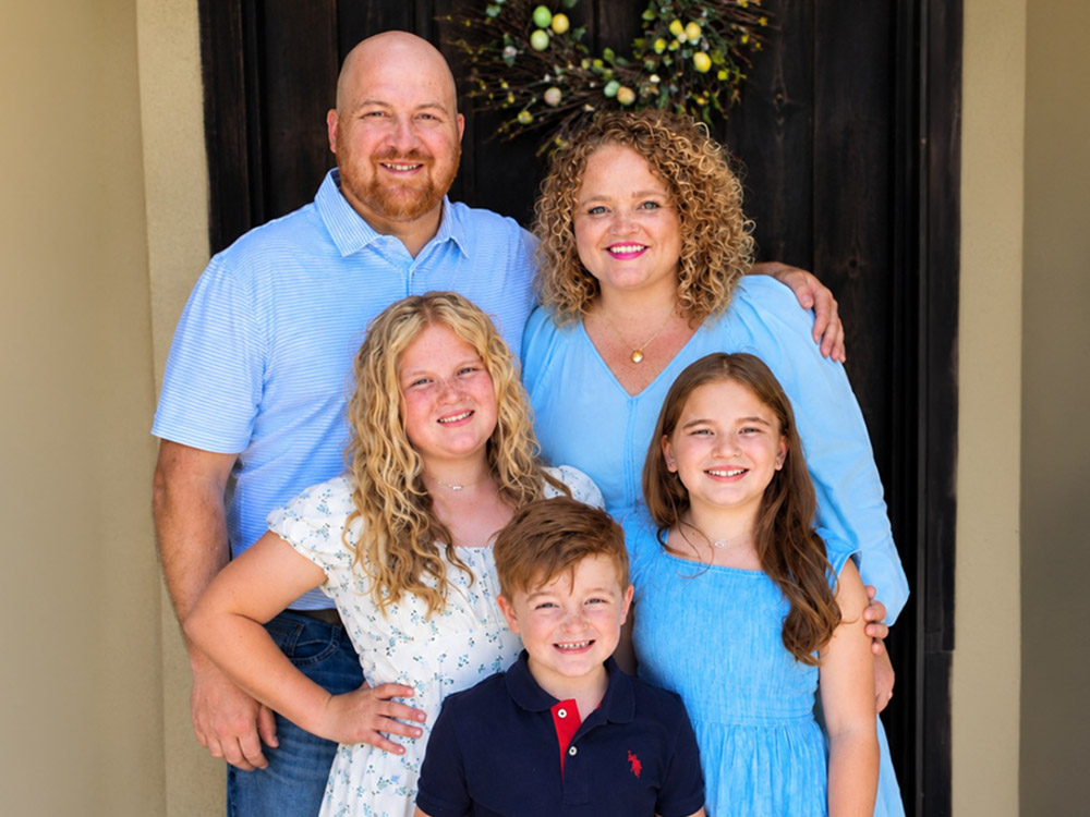 portrait of Kenny and Meghan Fisher with their three children