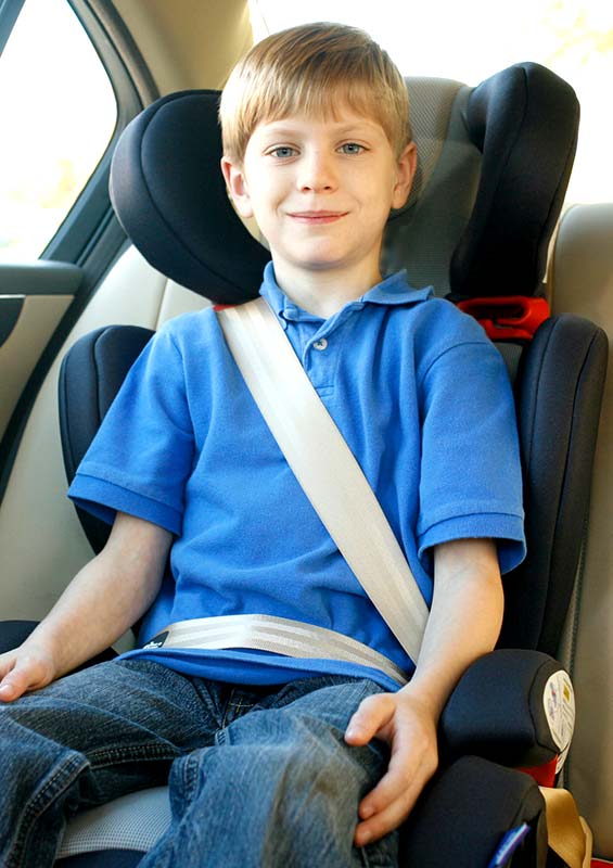 Child shown properly strapped in to a booster seat.