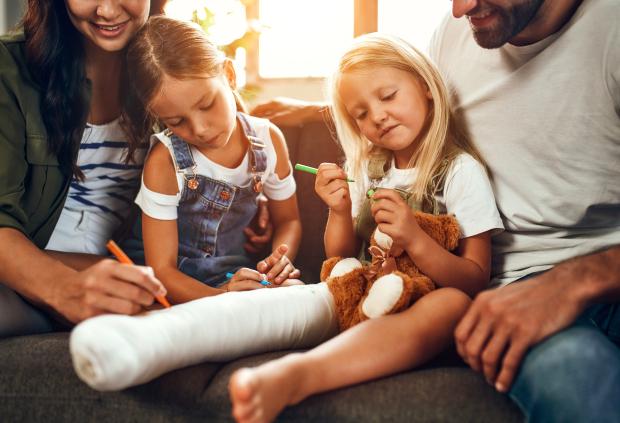 happy family decorates child's leg cast