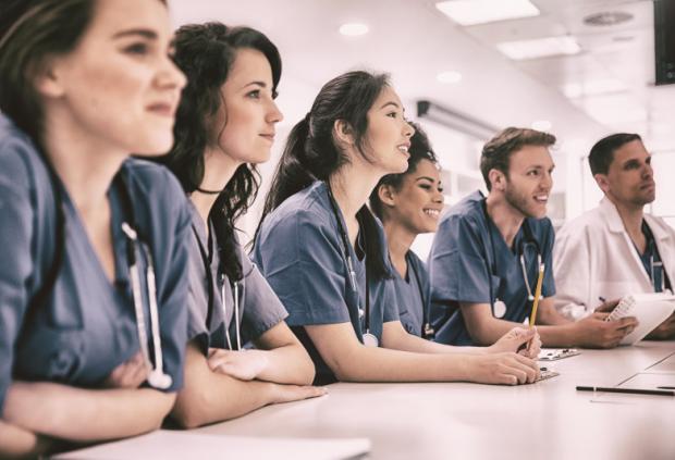 A row of medical students at a table in class