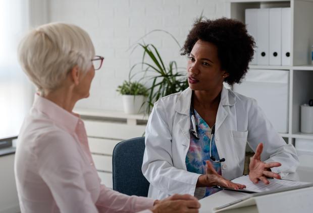 A doctor having a thoughtful conversation with her adult female patient