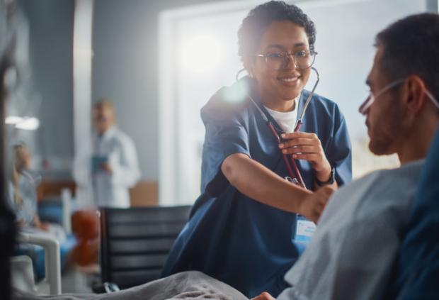 A doctor using her stethoscope to listen to a patient's heart