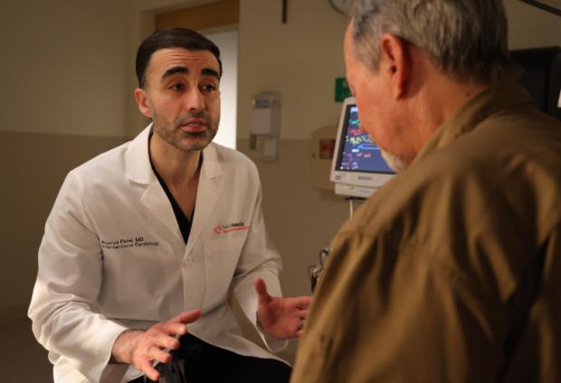 Doctor Fazel explains a procedure to an adult patient in clinic