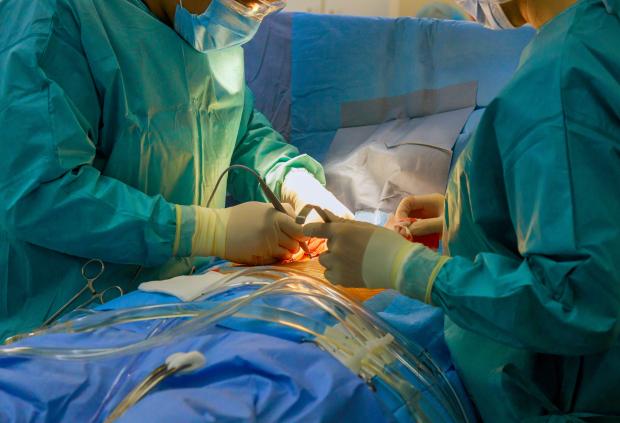 Surgical team performs open heart surgery in hospital operating room
