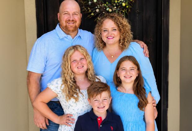 portrait of Kenny and Meghan Fisher with their three children