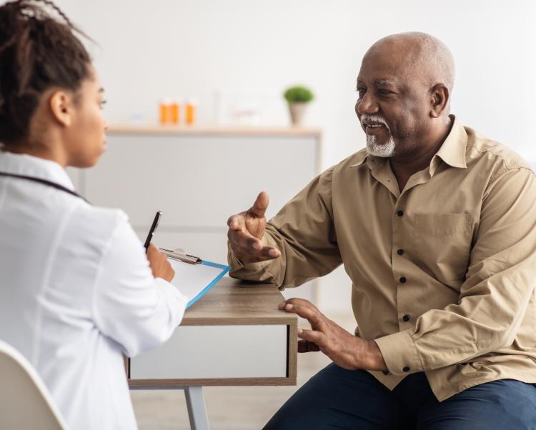Adult male patient smiles while talking to his physician