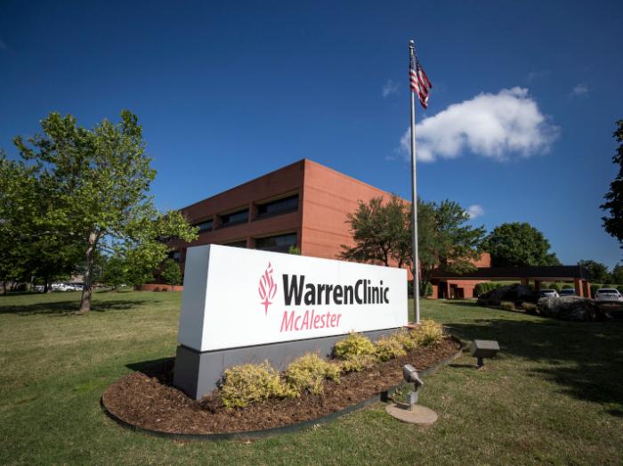 Exterior view of Warren Clinic McAlester with landscaping, flagpole and sign in the foreground