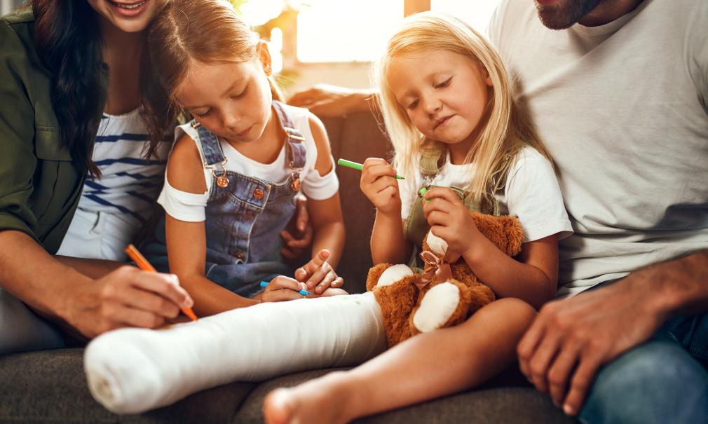 happy family decorates child's leg cast