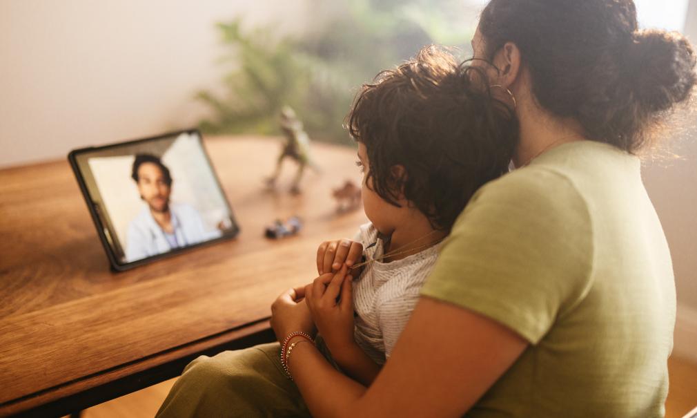A mother and child use a tablet to e-visit the doctor