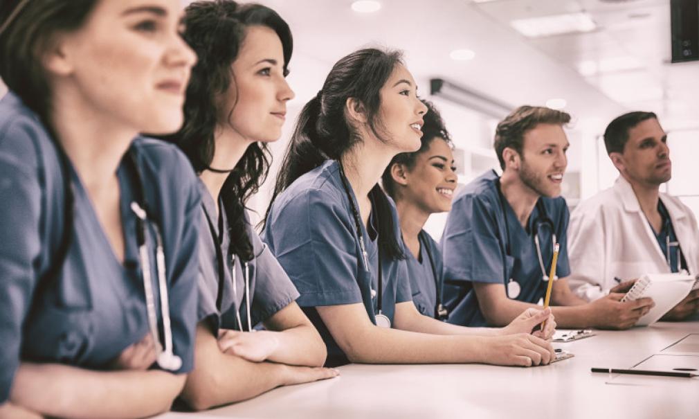 A row of medical students at a table in class