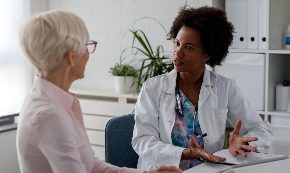 A doctor having a thoughtful conversation with her adult female patient