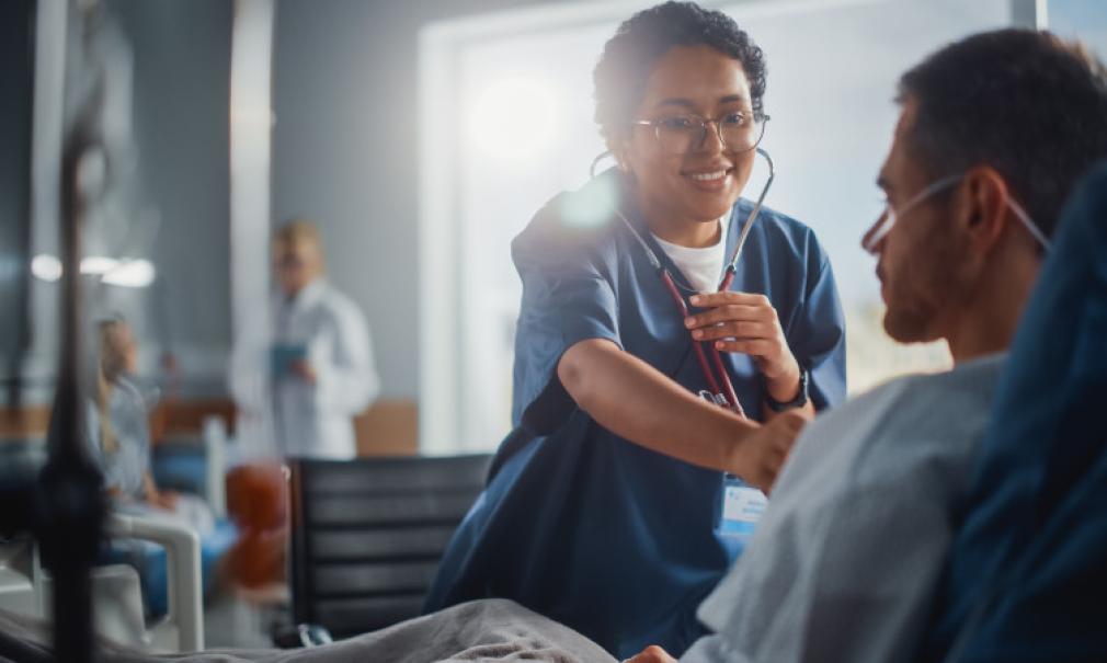 A doctor using her stethoscope to listen to a patient's heart