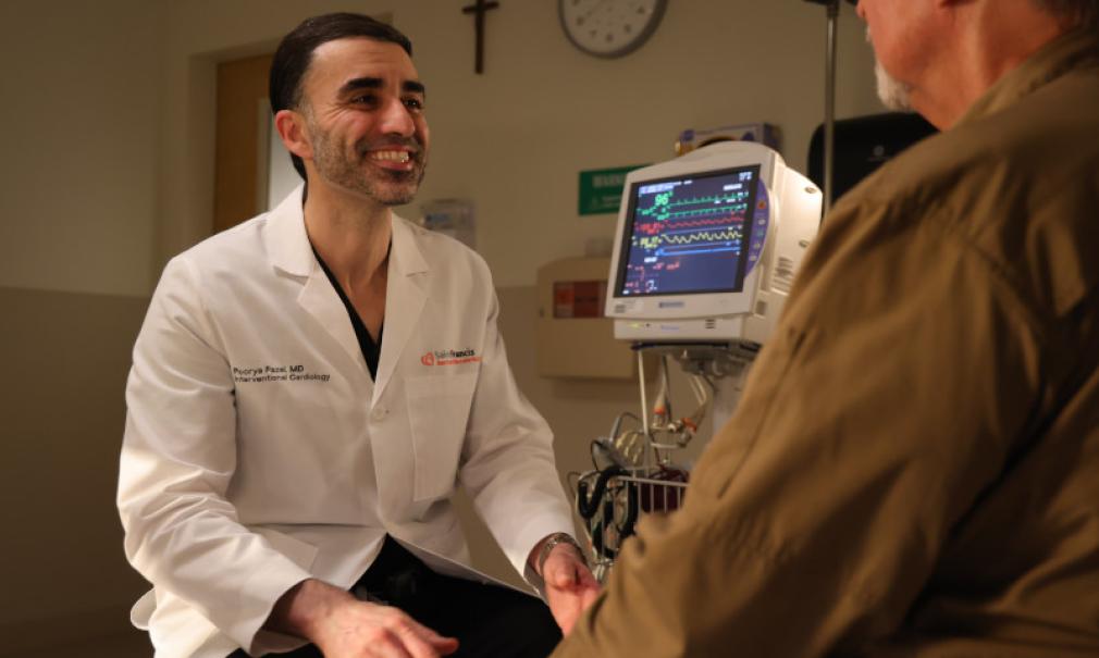 Doctor Fazel smiles while talking to an adult patient in clinic