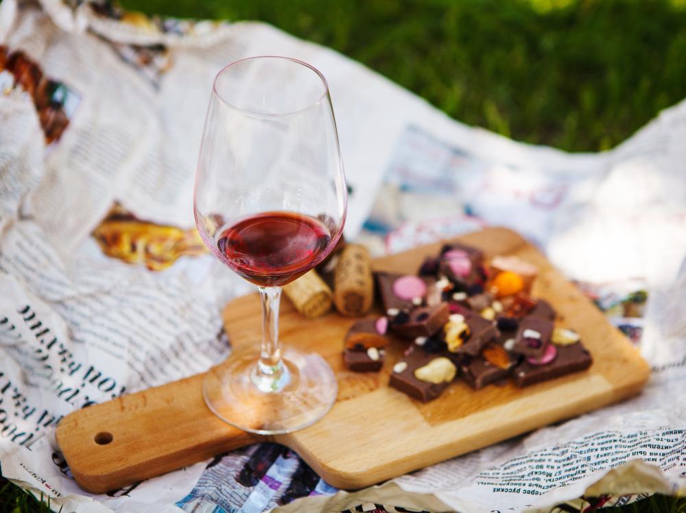 A tasting board with a glass of red wine and pieces of chocolate