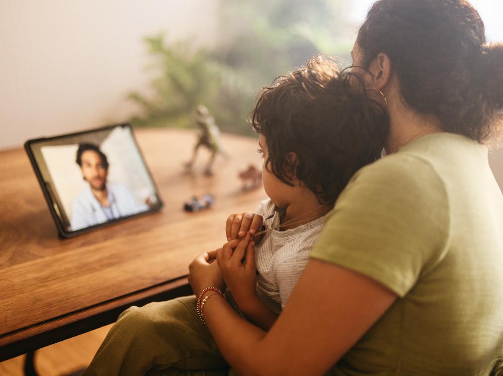 A mother and child use a tablet to e-visit the doctor