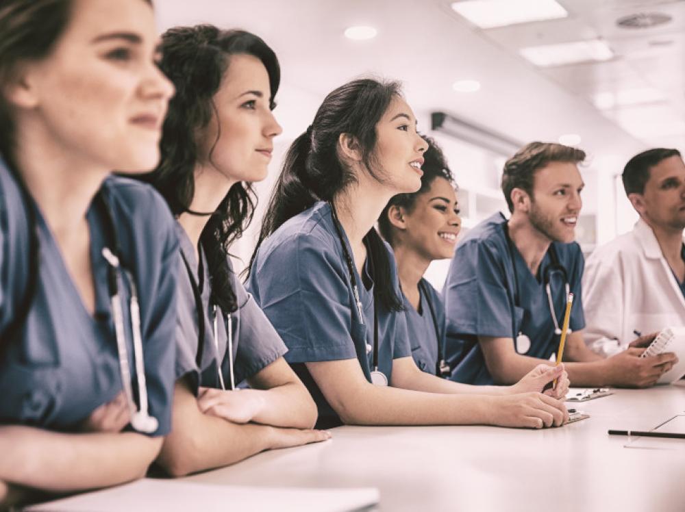 A row of medical students at a table in class