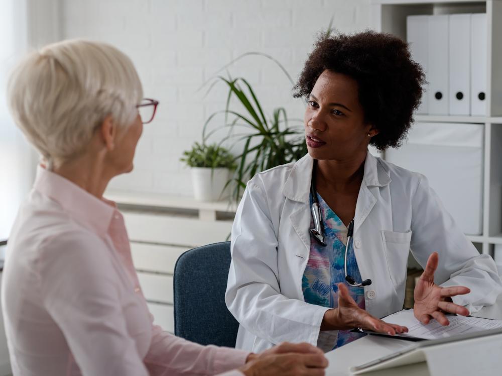A doctor having a thoughtful conversation with her adult female patient