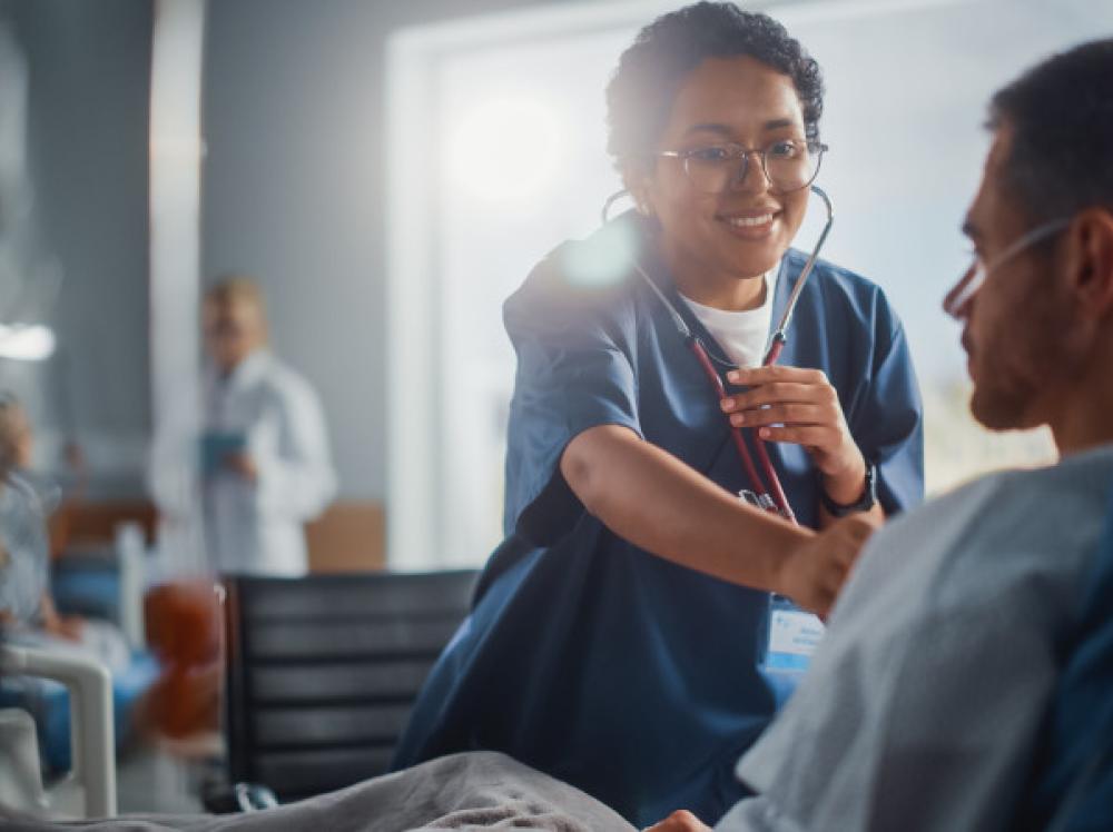 A doctor using her stethoscope to listen to a patient's heart