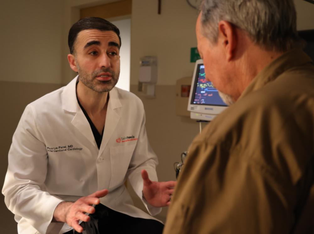 Doctor Fazel explains a procedure to an adult patient in clinic