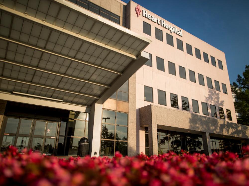 Exterior view of Heart Hospital entrance with blooming flowers at Saint Francis in Tulsa