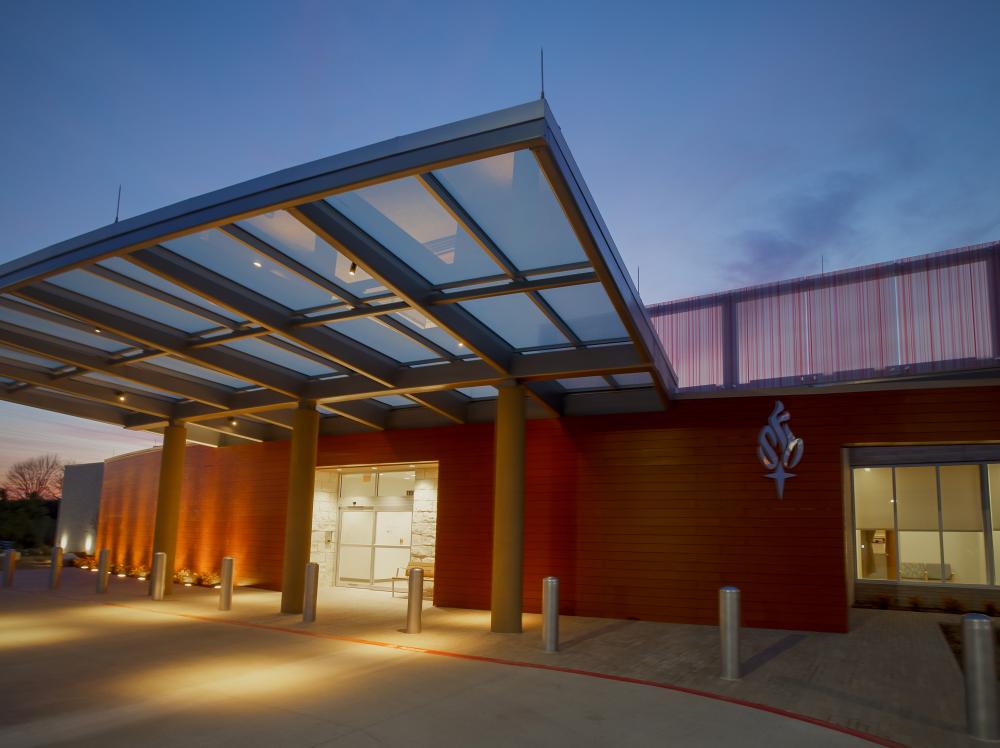 Warren Clinic Tulsa Hills exterior view of main entrance at dusk