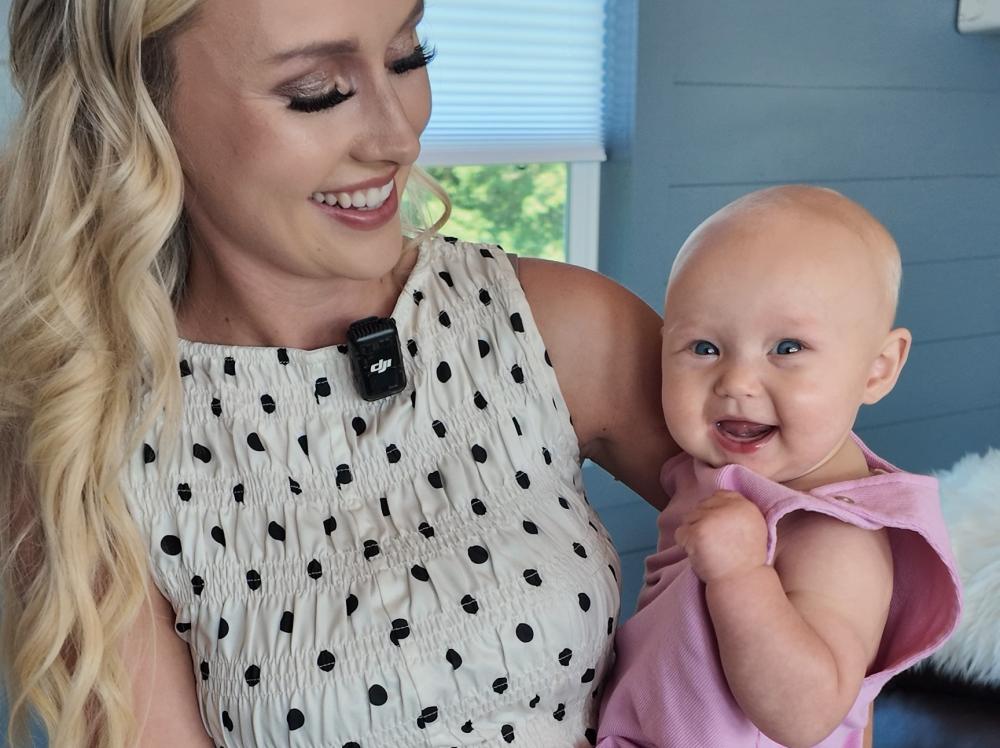 Photo of Ashlee and her baby Libby smiling in their living room